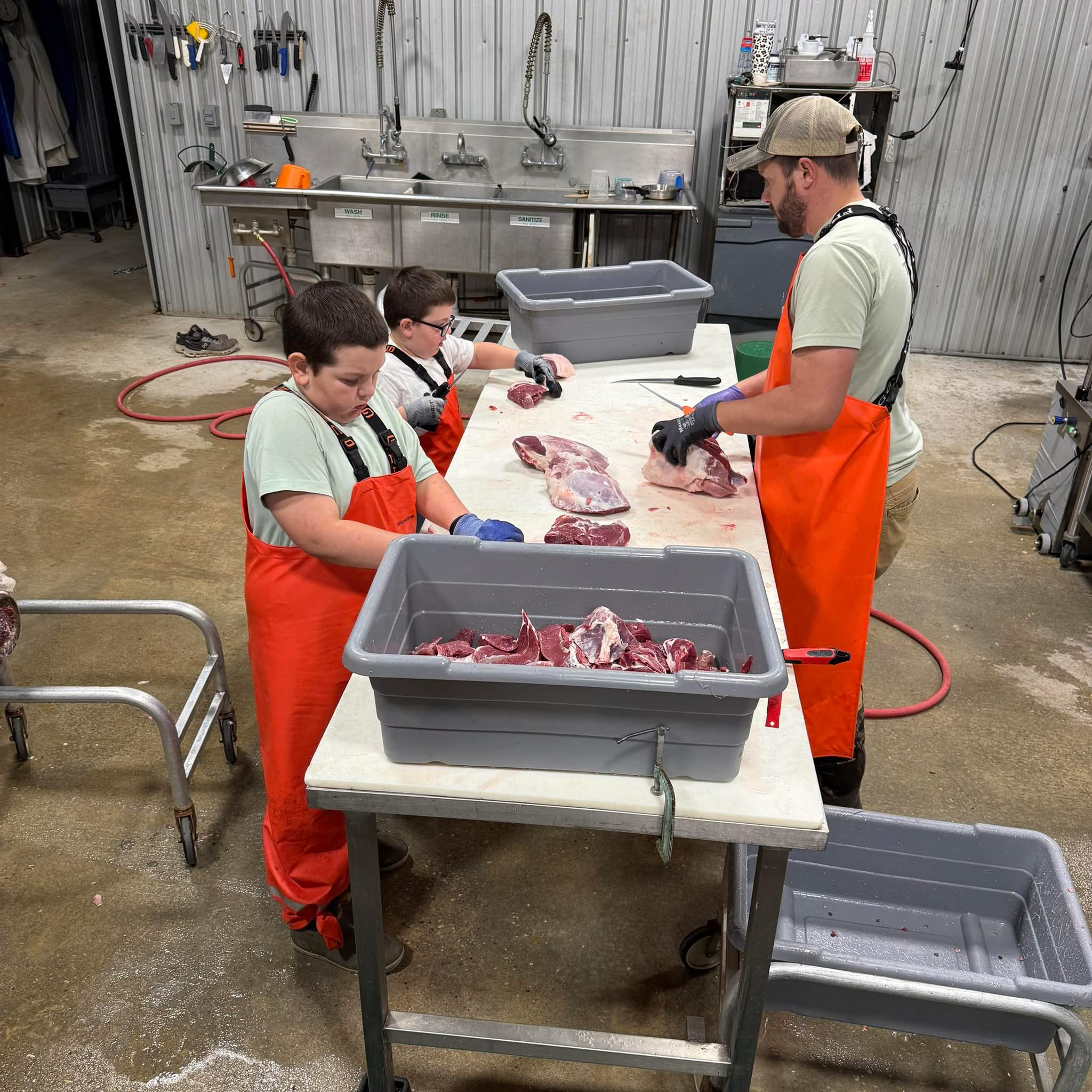 Marcus Phillips and his kids cutting meat at The Meat Hook