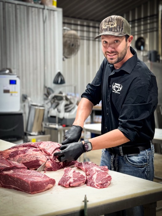 Butcher cutting ribeyes at The Meat Hook