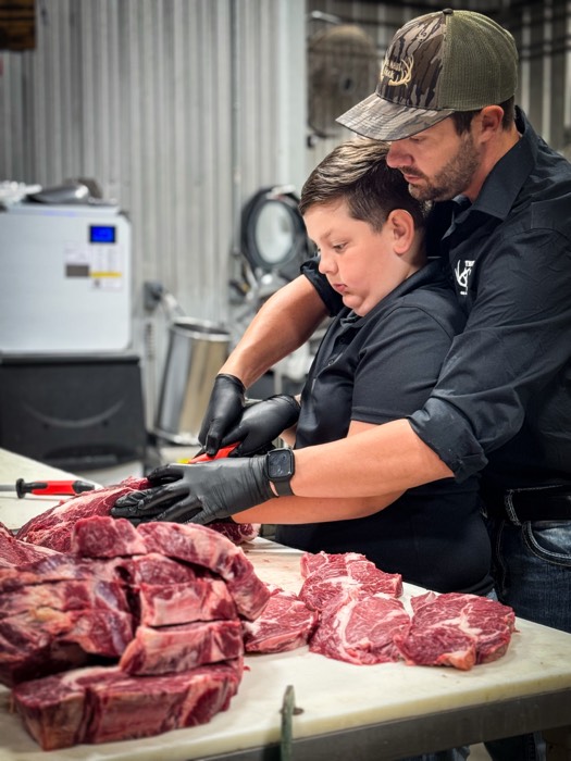 Close-up of father and son cutting meat at The Meat Hook